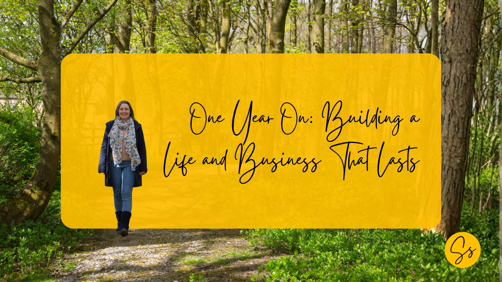 Susannah Simmons walking along a wooded path in spring, surrounded by trees, with overlaid text reading “One Year On: Building a life and business that lasts.”