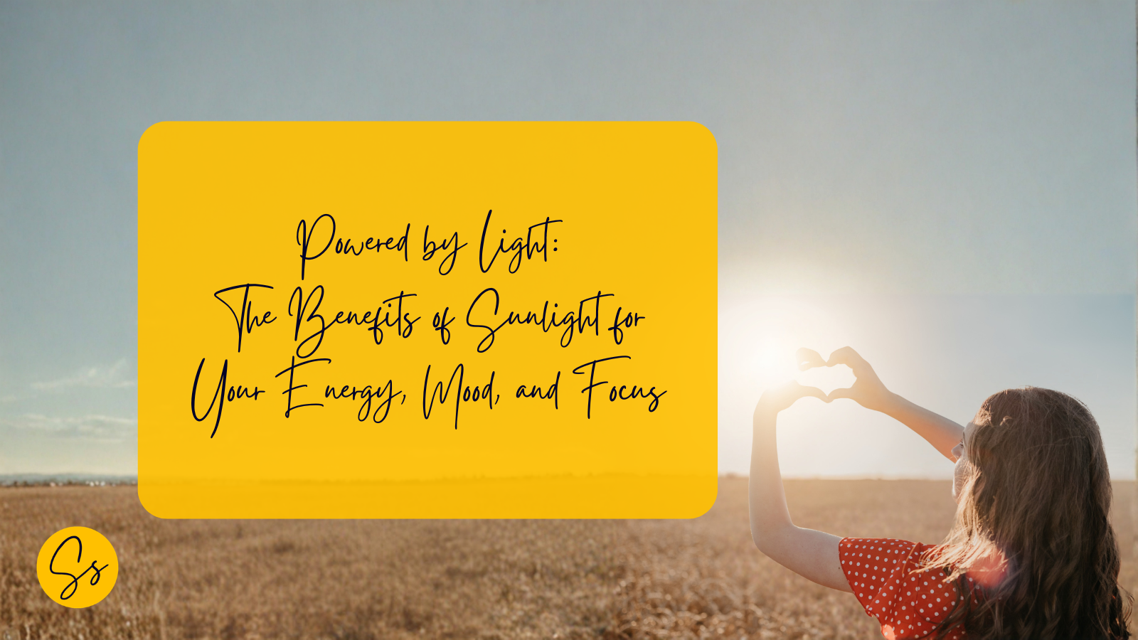 Person standing in a sunlit field shaping hands into a heart, representing the benefits of sunlight for energy, mood and focus.